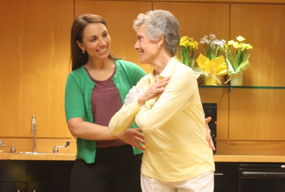 Physical therapist helping woman with standing core exercises.