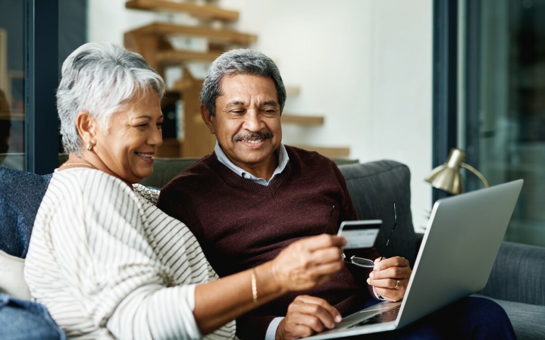 couple using a laptop while sitting on a couch