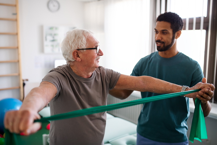 young physiotherapist exercising with a senior patient