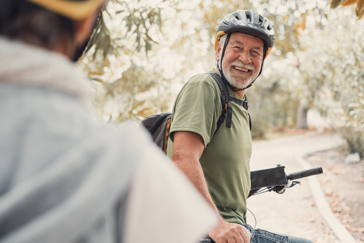 two seniors people riding bikes together outdoors